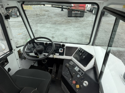 Cab interior of TJ6500 truck showing steering wheel, instrument cluster, pedals, and dashboard with gauges and controls.