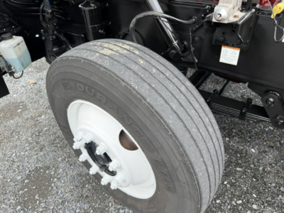 Capacity TJ6500 wheel and tire assembly showing Dunlop tire and white steel rim with lug nuts.