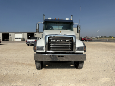Front view of a white 2027 Mack GR64FT conventional daycab truck showing large grille with MACK lettering and bumper.