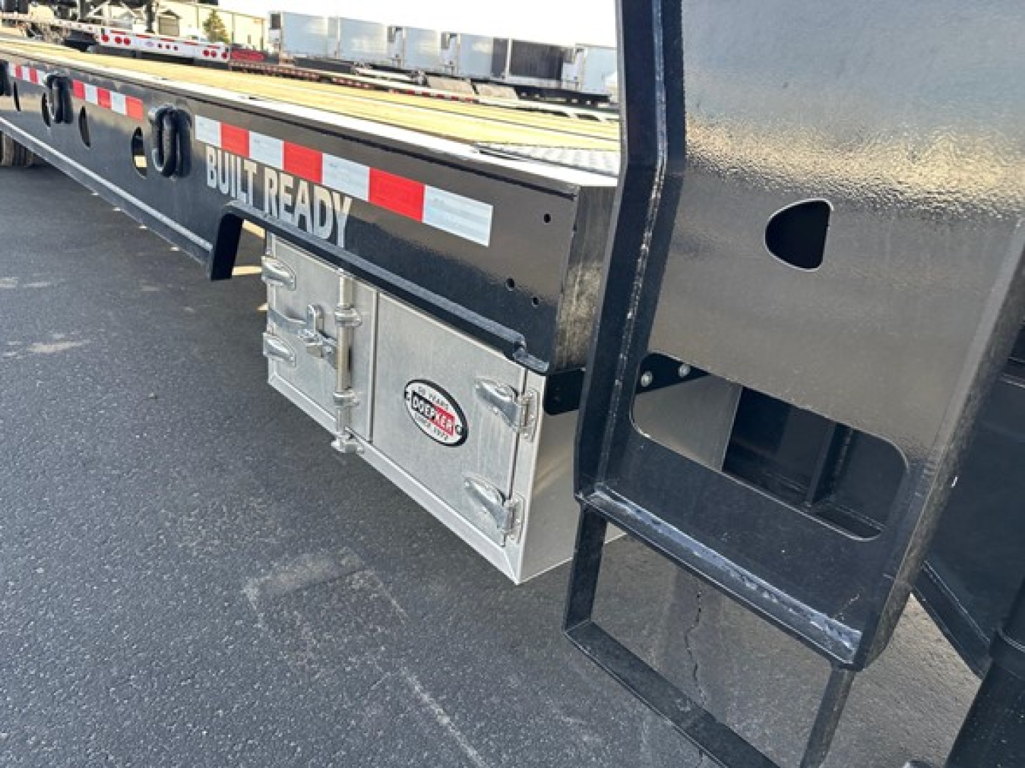 Doepker trailer side showing Built Ready lettering and a silver toolbox mounted under the bed.