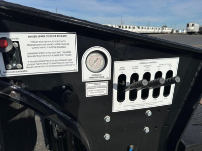 Trailer control panel with dashboard gauges and levers; visible labels read 'Hinged Upper Coupler Release' and 'Vernible Pressure Gauge' with multiple toggle levers and instruction text.