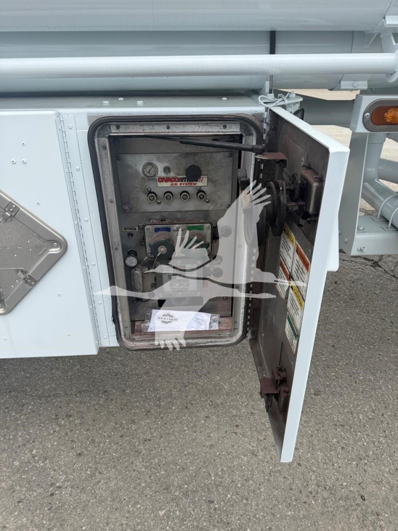 Compartment door on side of trailer open showing control panel and connectors.