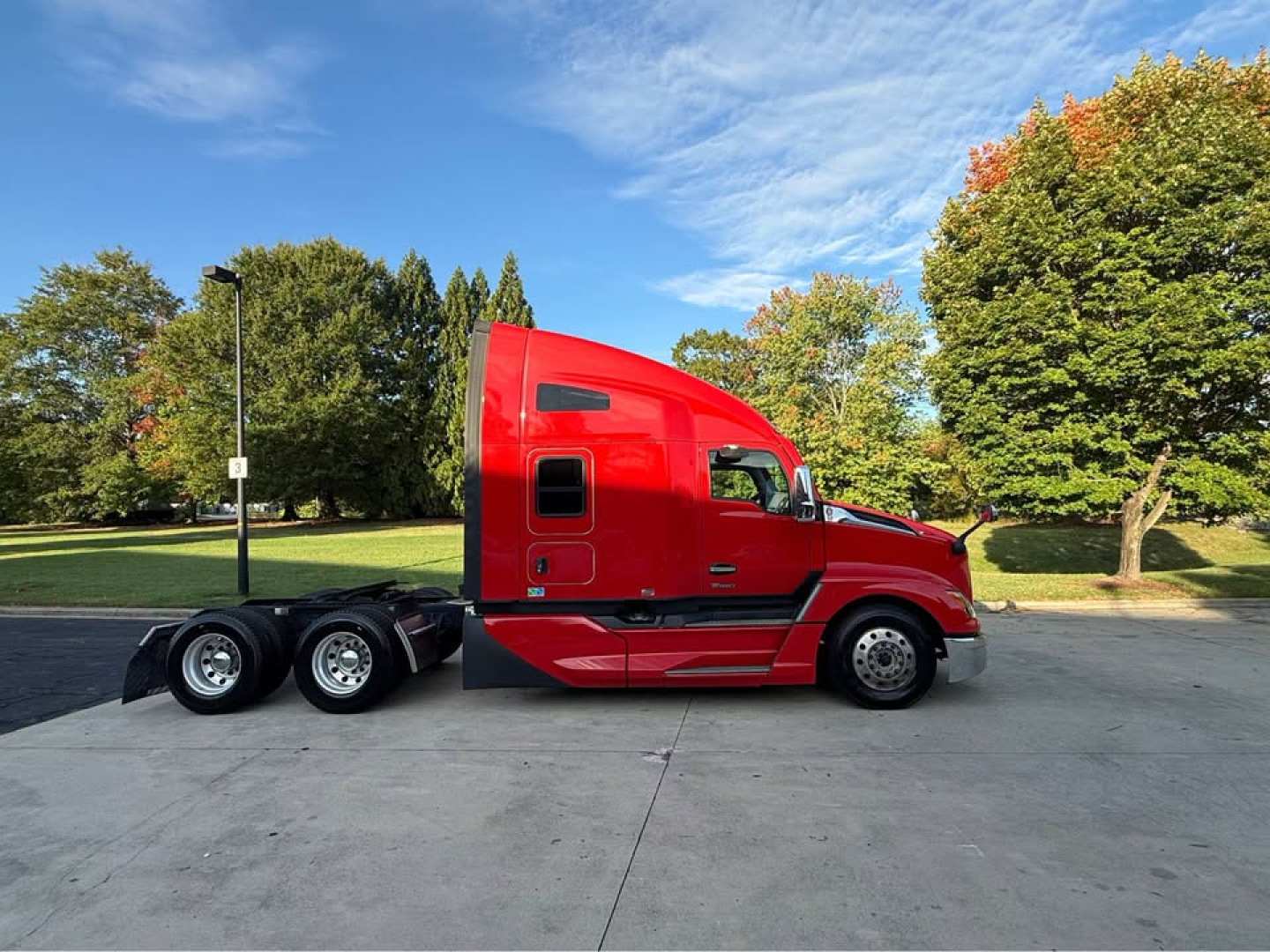 Kenworth T680 tractor in red side profile showing sleeper cab and dual rear axles.