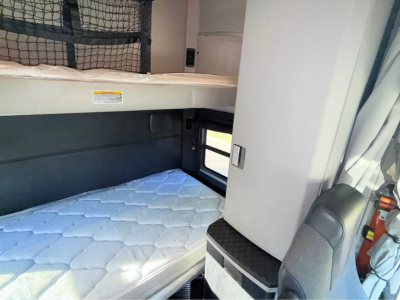 Kenworth T680 sleeper cab interior with bunk bed mattress and seating area visible