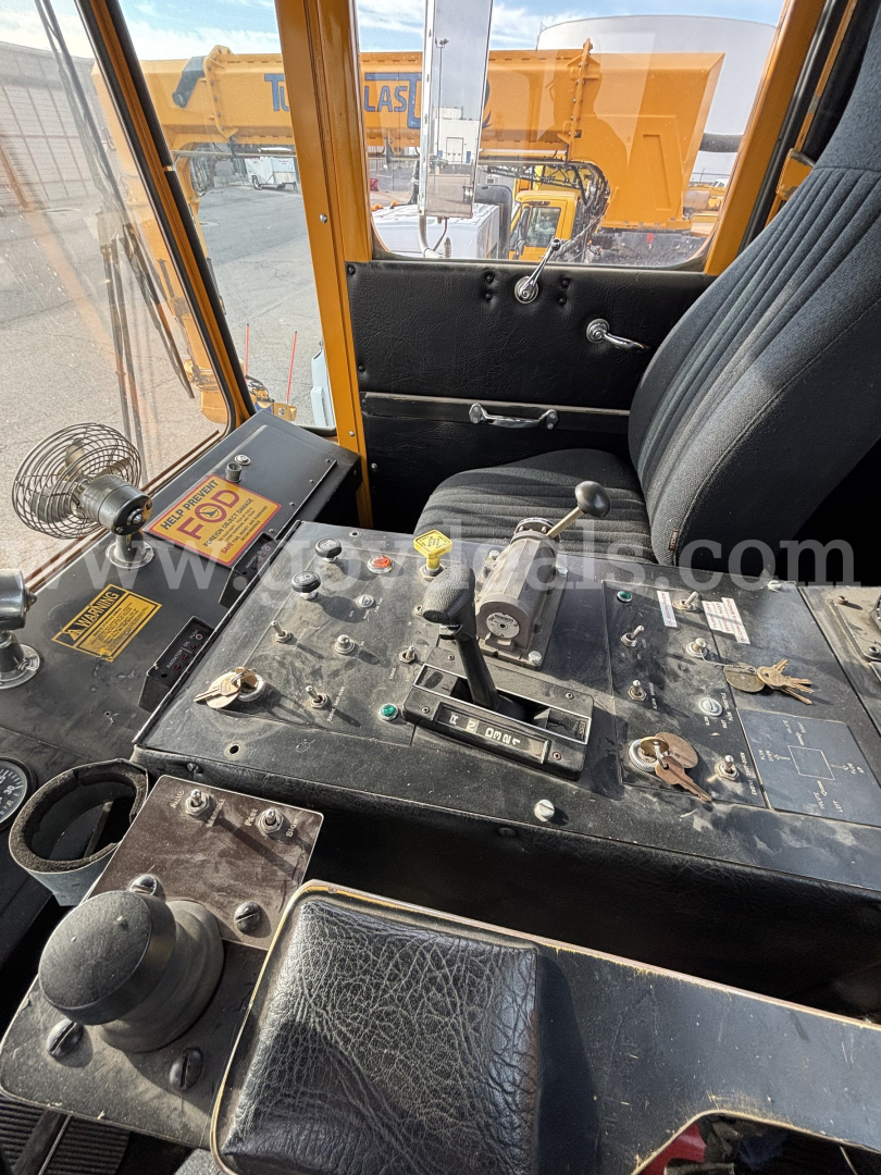 Cab interior of a Kodiak heavy equipment vehicle showing control levers, pedals, and a dashboard with switches and labels.