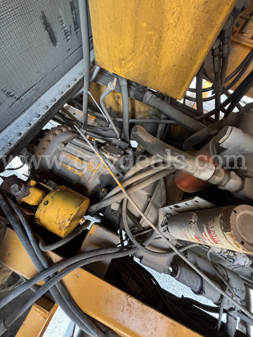 Kodiak CD6072-119 equipment bay showing engine components, hydraulic hoses, and yellow-painted parts.