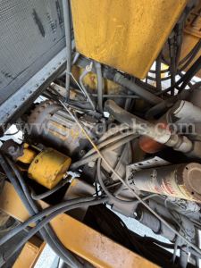 Kodiak CD6072-119 equipment bay showing engine components, hydraulic hoses, and yellow-painted parts.