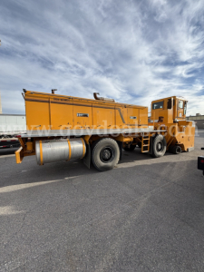 Orange Kodiak CD6072-119 industrial equipment truck with a large cylindrical tank and rear wheels, side hoses, and cabin visible.