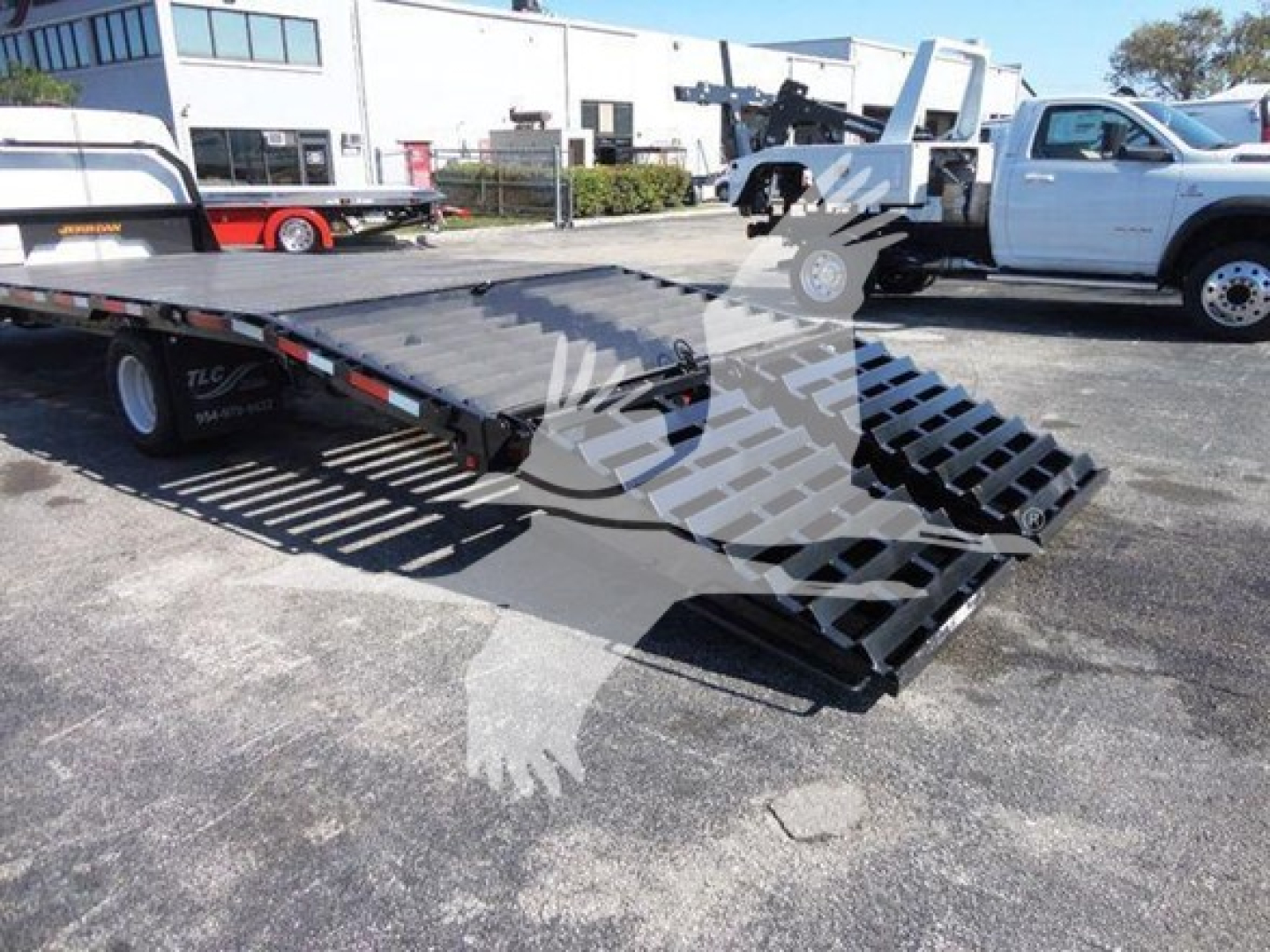 Flatbed tow truck with a lowered metal deck and loading ramps, 2011 Ford E450 lot vehicle; VIN 1FDXE4FS9BDA06273 visible in listing context