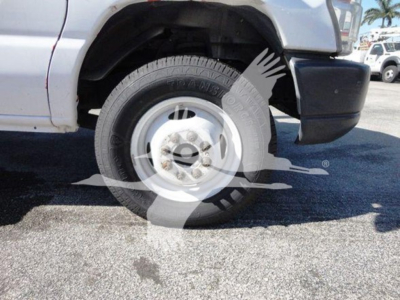 Ford E-Series truck wheel and front fender showing tire and rim with partial bumper.