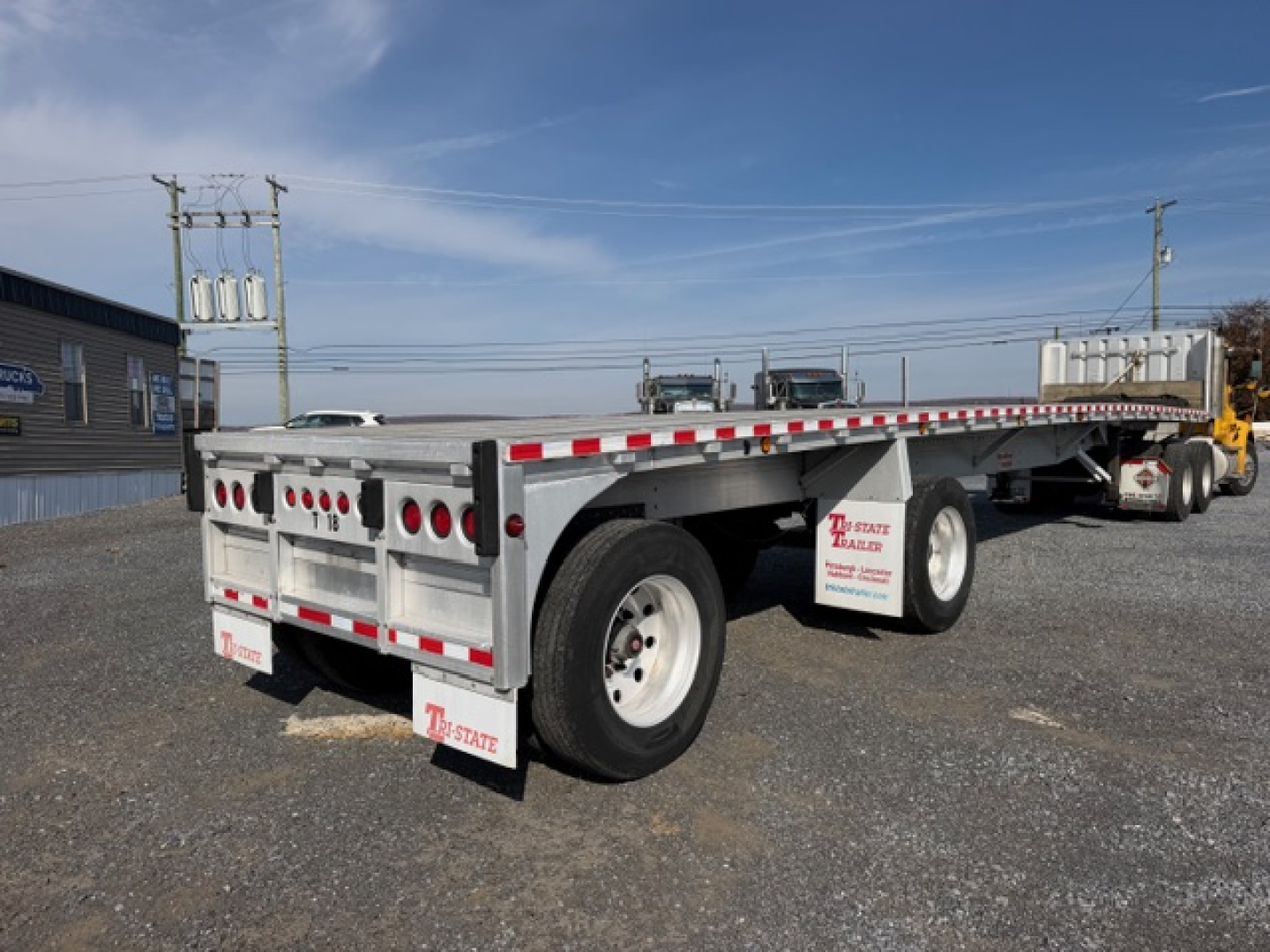 Flatbed trailer shown from rear-left side with dual axles and 45x96 dimensions, white with red/white safety stripes and mud flaps, 2004 Reitnouer MaxMiser tag visible.