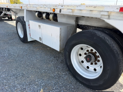 Flatbed trailer wheel area showing dual rear axle, white storage box, and chrome18.5 inch rims on a 2004 Reitnouer MaxMiser 45x96 trailer.