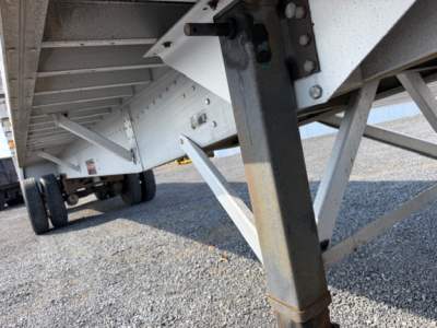  trailer undercarriage showing steel support legs and side-frame of a flatbed trailer.