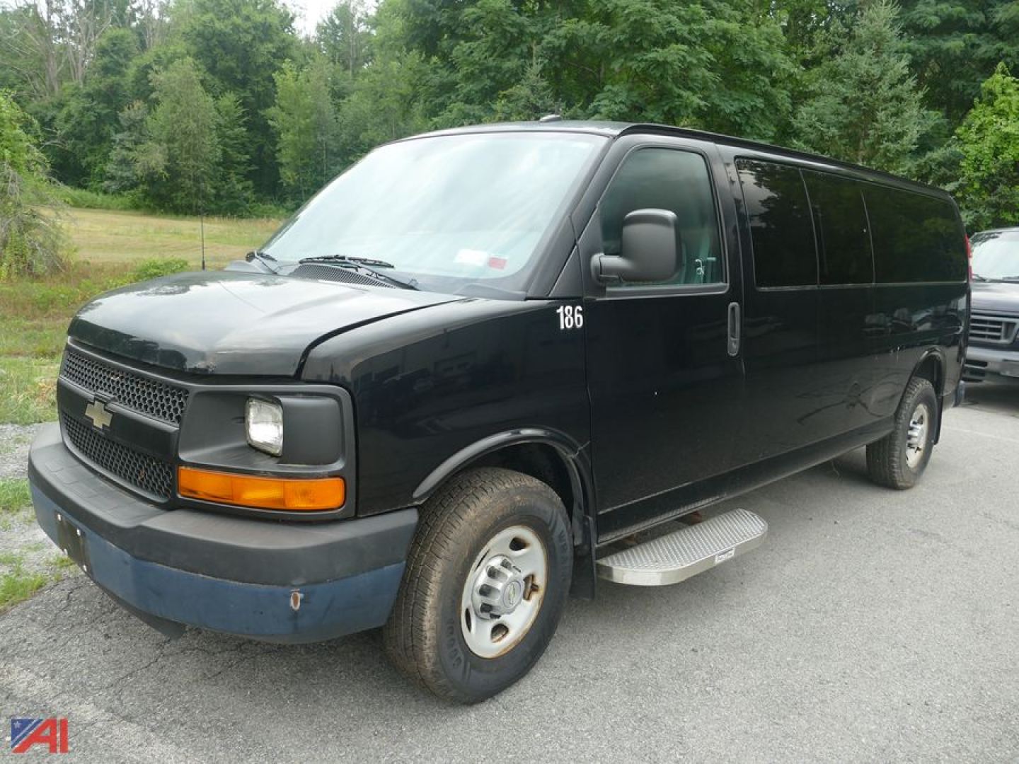 Black 2013 Chevrolet Express LS 3500 extended cargo van side view showing front grille, passenger side, running boards, and wheel wells.
