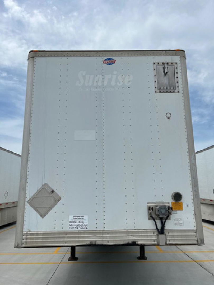 Rear view of a 2011 utility van trailer showing Sunrise branding, access door, electrical plug, and support legs.