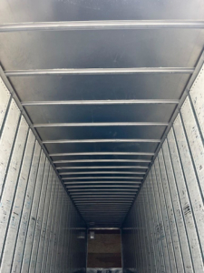 Trailer interior showing metal sidewalls and roof ribs of a cargo van/trailer.
