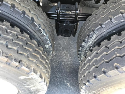 Ranco Ed60-38 dump trailer wheel area with dual rear tires and suspension components visible between them.