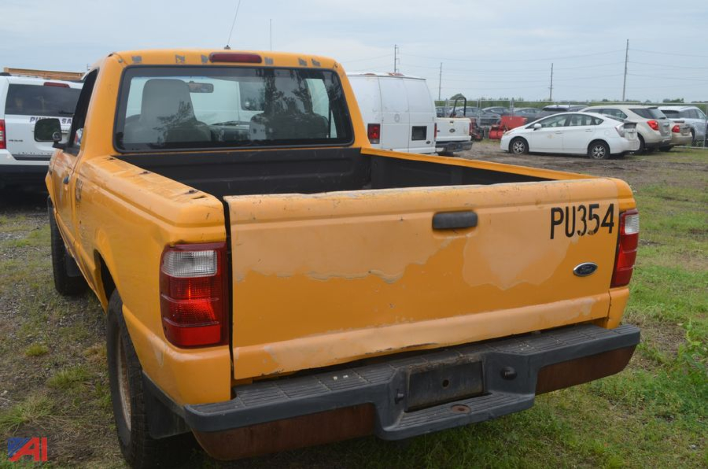 Ford Ranger pickup truck bed rear view with yellow paint and tailgate area showing PU354 written on tailgate.