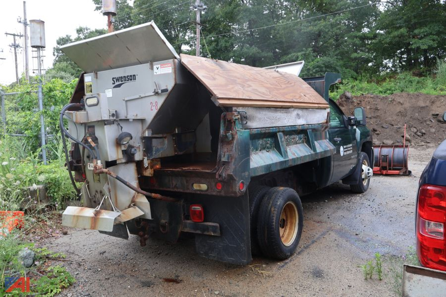 Dump truck with plow and sander attachment rear view showing Swenson spreader and dump body.