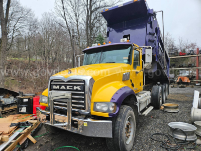 Dump truck: 2014 Mack GU713 with yellow cab and purple dump bed, front chrome bumper guard, VIN 1M2AX04C3EM019013 seen on listing photo.