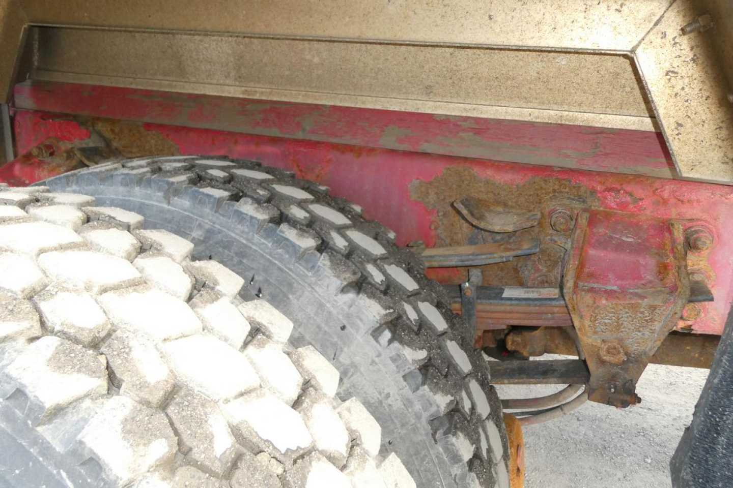 Sterling L7500 rear wheel and suspension components showing heavy-duty tire, leaf spring, and hitch area with rust-colored metal.