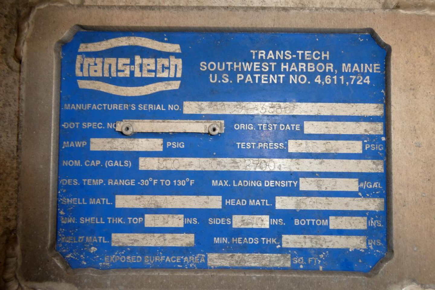 Trans-Tech label on equipment showing Manufacturer's Serial No., DOT Spec No., Orig Test Date, Test Press, MAWP, PSIG, NOM. CAP (GALS), DES. TEMP. RANGE, MAX LADING DENSITY, SHELL MATL, HEAD MATL, FRONT/REAR THK, etc. Brand: Trans-Tech, Sou
