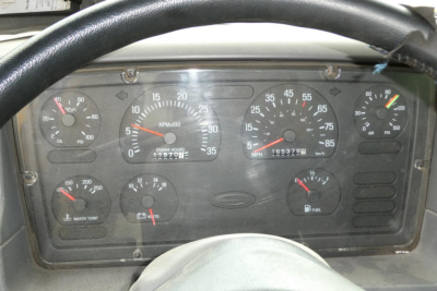 Dashboard and instrument cluster of a 1999 Sterling L7500 truck showing gauges including RPM, speedometer, fuel, coolant temp, oil pressure, voltmeter, and engine hour readings.