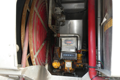 View inside engine bay of a Sterling L7500 truck showing a compact diesel or gas engine with yellow valve and nearby hoses and a red cylindrical component.