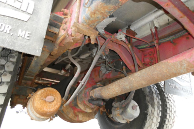 Sterling L7500 undercarriage showing drivetrain and suspension components with rusty frame and exposed exhaust.