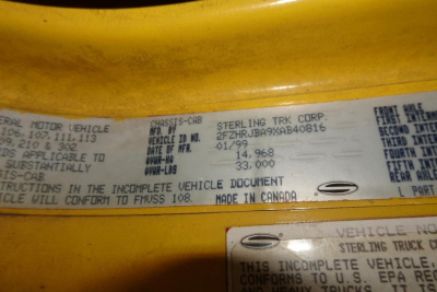 Label showing VIN and vehicle information: 'STERLING TRK CORP' and various weights and markings; text is small and dense across a metal plate.