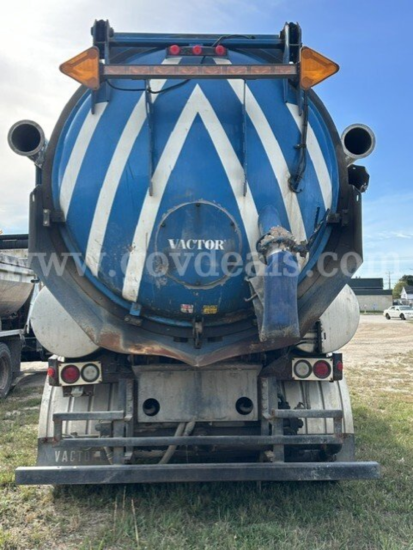 Rear view of a blue and white striped Sterling L7501 vacuum truck tank showing rear bumper, taillights, and chassis.