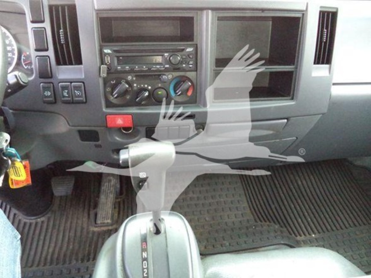 Isuzu NRR dashboard and center console with gear selector and climate controls in view.