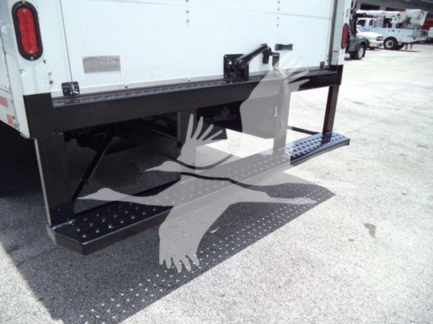 Isuzu NRR rear underride steps and bumper; truck bed with black metal frame and perforated steps visible.