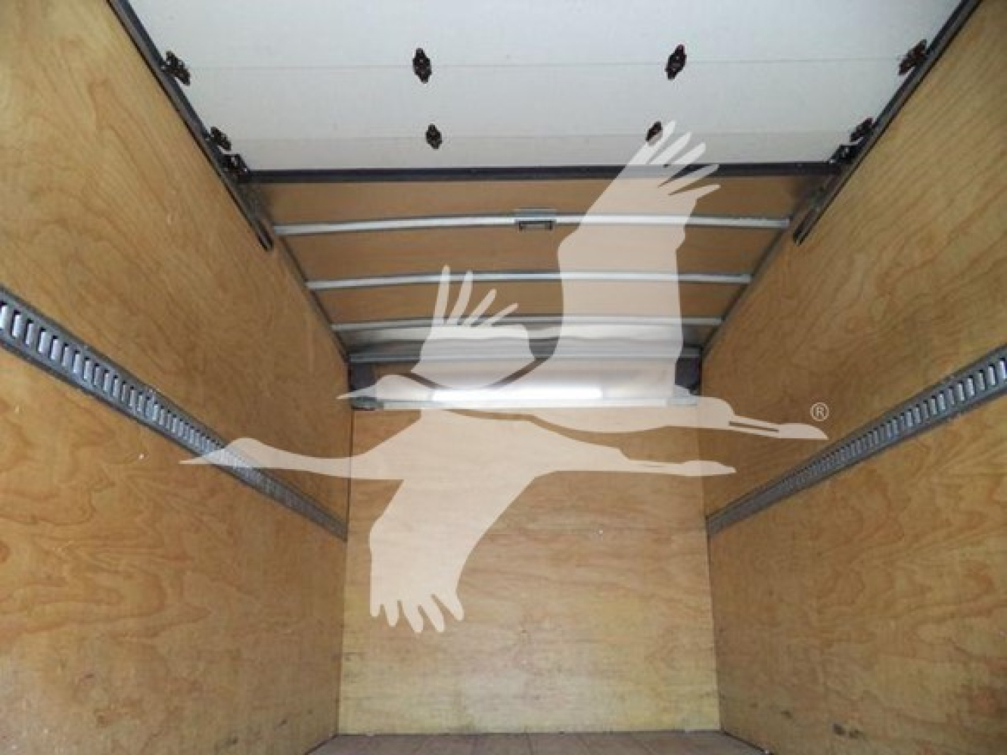 Isuzu NRR truck cargo area showing wooden box walls and metal rails inside the box, empty cargo space.