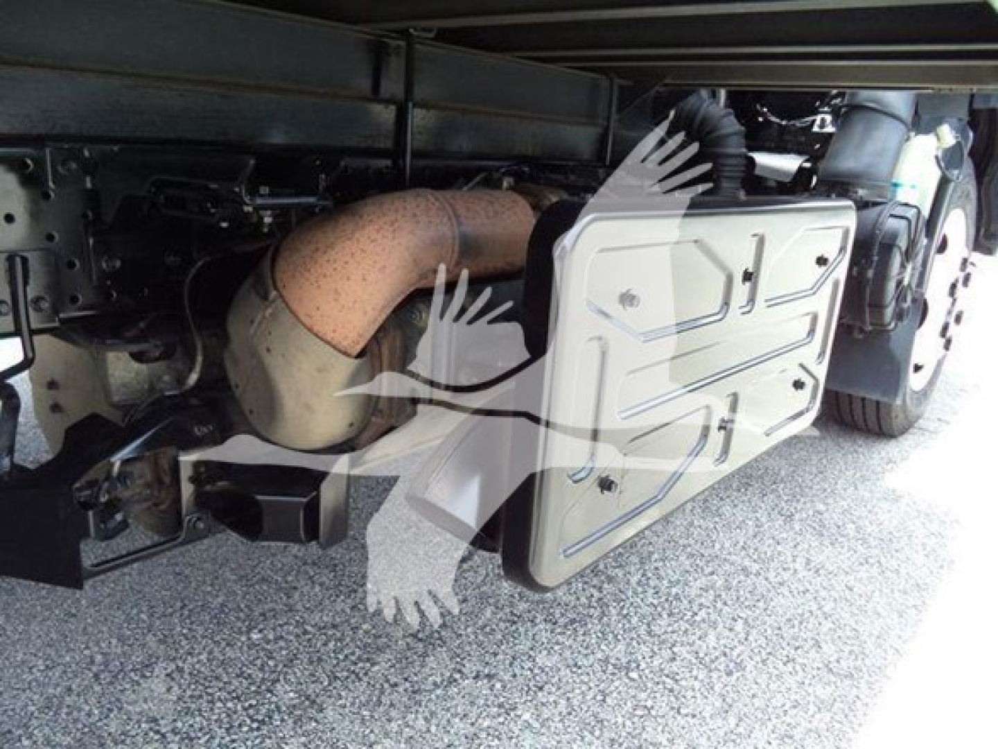 Isuzu NRR truck undercarriage showing exhaust manifold and protective side panel with bolts.