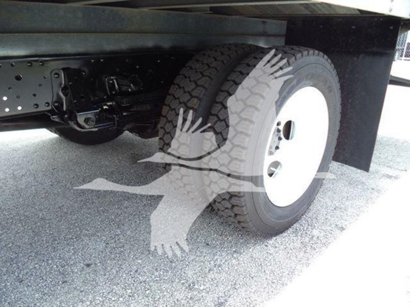 Isuzu NRR truck dual rear wheels undercarriage view showing suspension, chassis, and wheel with white rim.