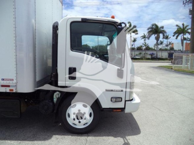 Isuzu NRR box truck cab front-side view showing door, windshield, front tire, and side mirror with a box trailer adjoining.