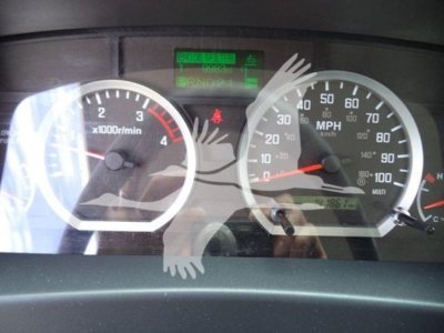 Isuzu NPR/NRR gauge cluster showing tachometer and speedometer with green digital readout above; odometer and dashboard in view.