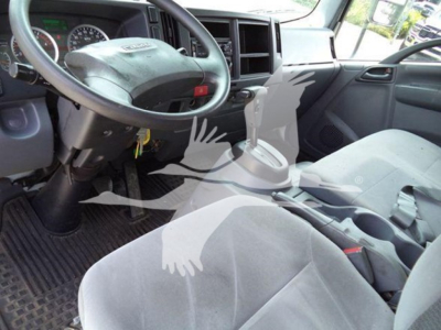 Isuzu truck interior showing steering wheel, dashboard, and gear shifter; driver's seat and center console visible.