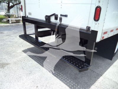 Isuzu NRR rear/side view showing heavy-duty fold-out cargo step/bumper with textured stepping surface and black metal platform.