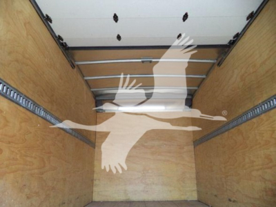 Isuzu NRR truck cargo area showing wooden box walls and metal rails inside the box, empty cargo space.