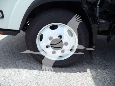 Isuzu NRR wheel and front tire view with white steel wheel and hubcap, part of a box truck.