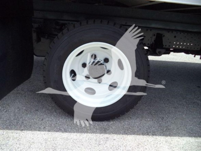 Isuzu NRR wheel/tire visible under box truck with white steel rim.