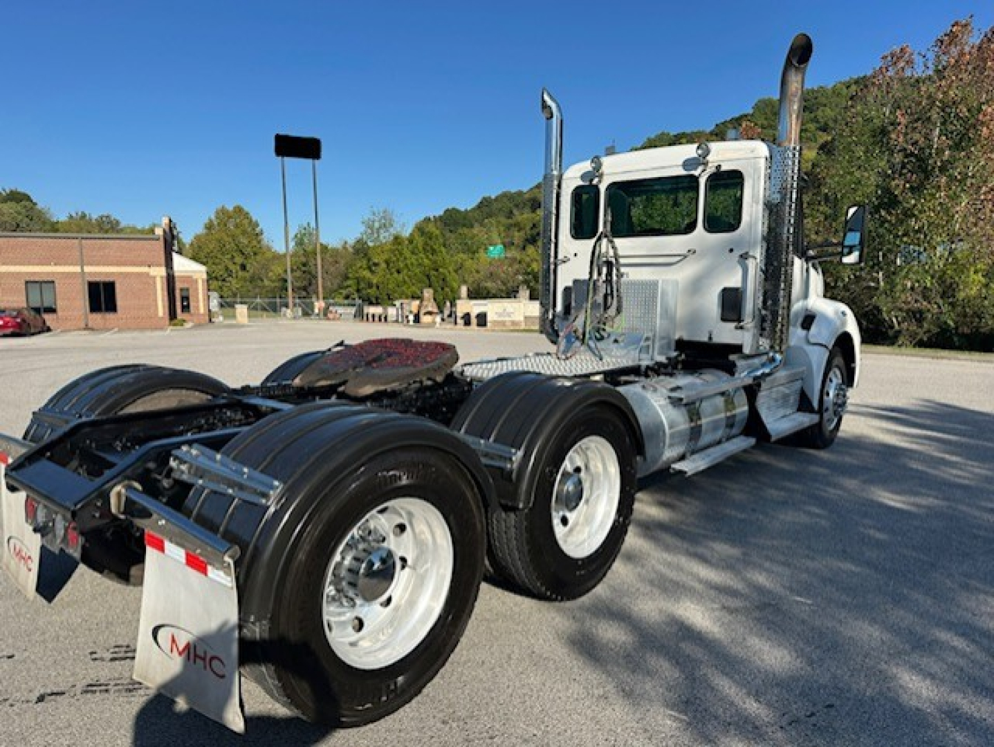 Kenworth T880 conventional daycab truck chassis view showing rear wheels and exhaust stacks.
