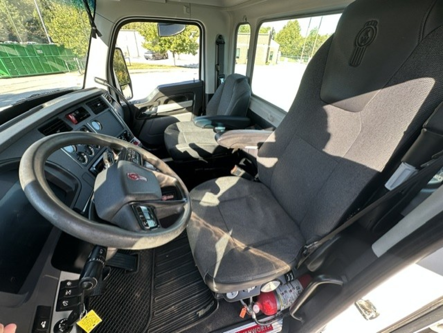Kenworth T880 truck cab interior showing steering wheel, driver seat, dashboard, and control panel.