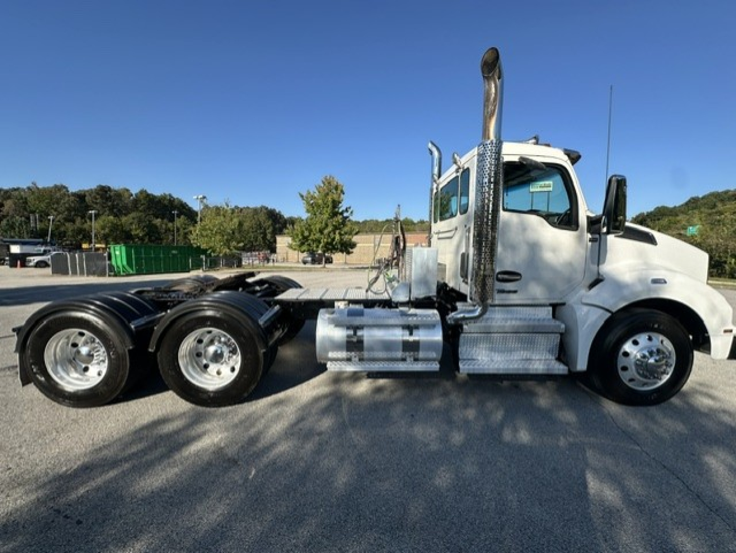 Kenworth T880 tractor side view showing cab, chrome exhaust stack, fuel tanks, and dual rear axles. Side text not legible; no visible labels or numbers.