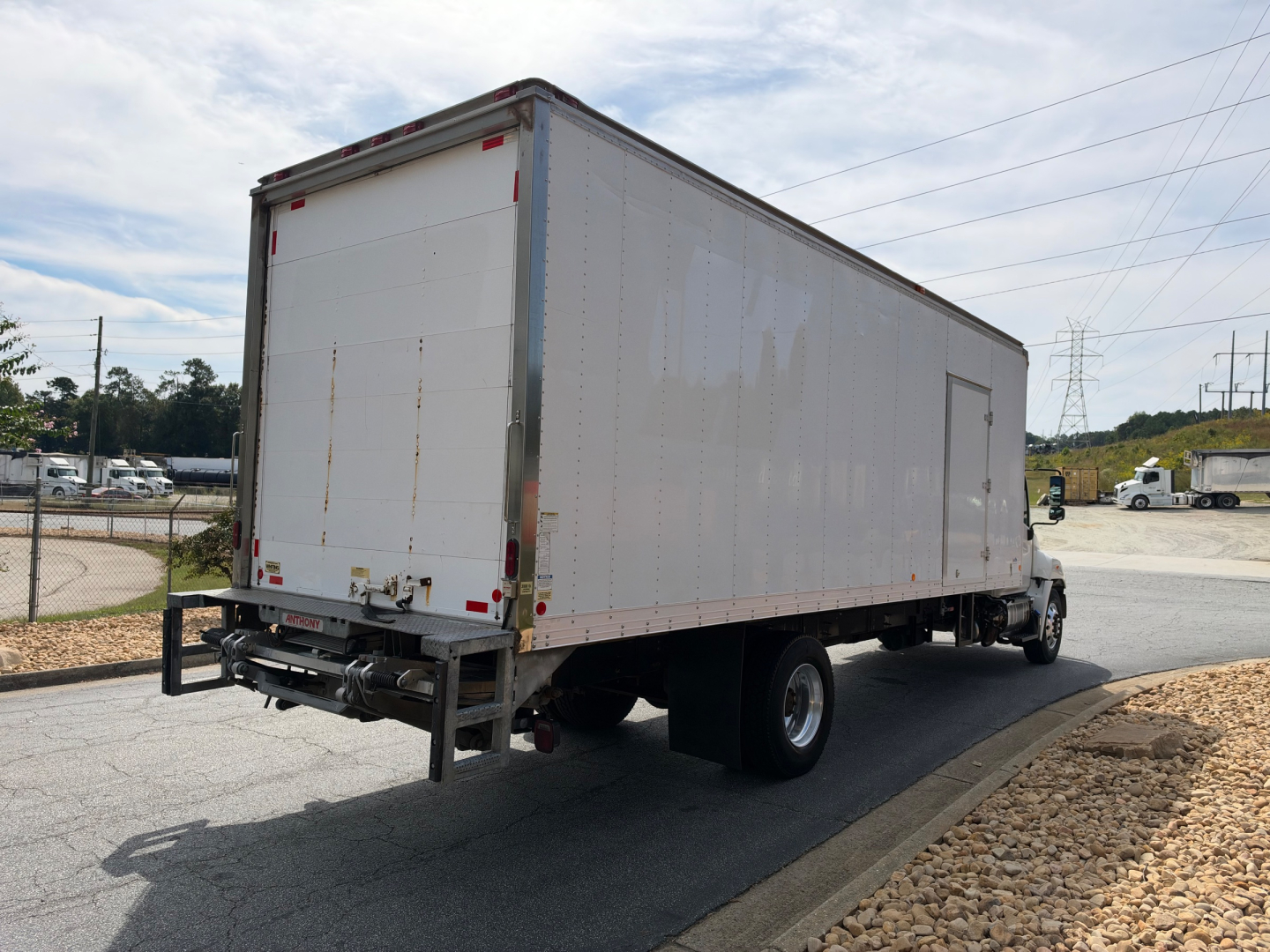 Box truck rear and side view of a 2019 Hino 268A box truck showing rear doors and reflective tape.