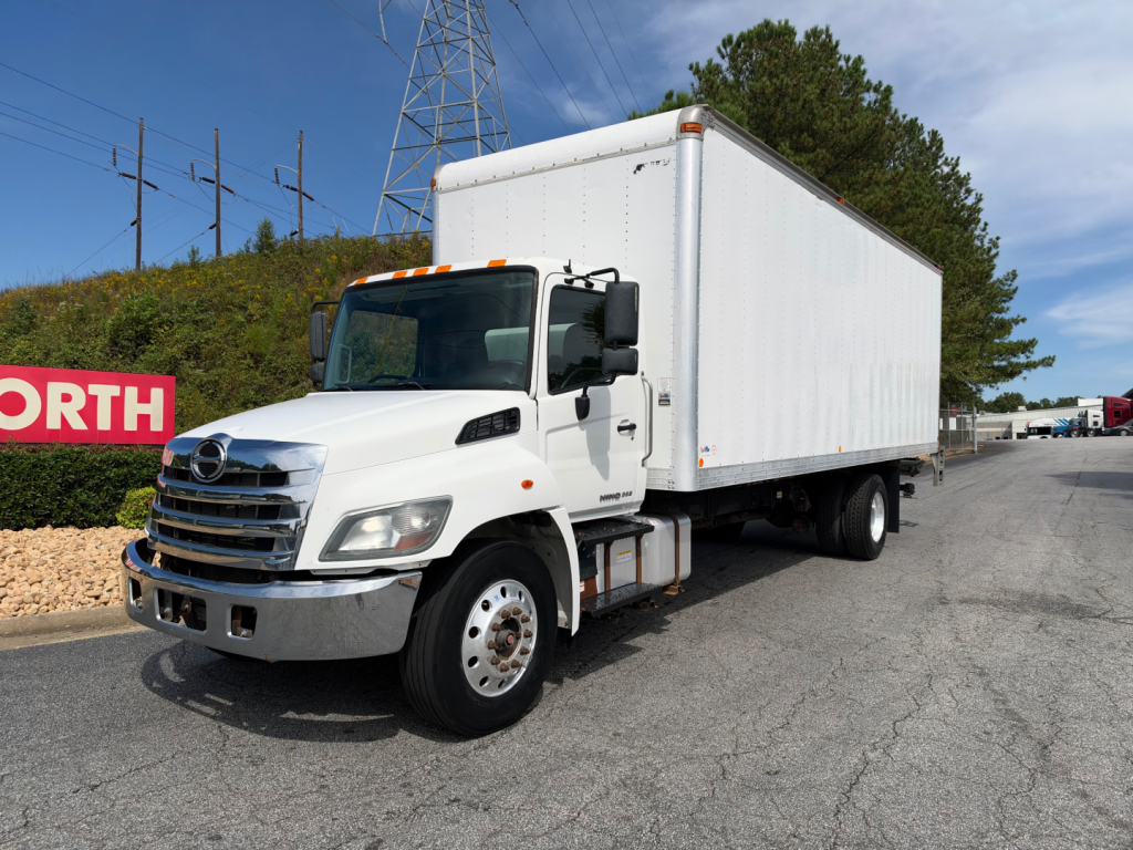 Box truck 2019 Hino 268A side view showing cab and large cargo box with white exterior and dual rear wheels.