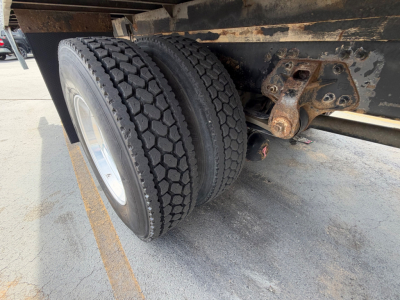 Truck axle area showing dual rear wheels and suspension components of a 2019 Hino 268A box truck.
