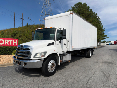 Box truck 2019 Hino 268A side view showing cab and large cargo box with white exterior and dual rear wheels.